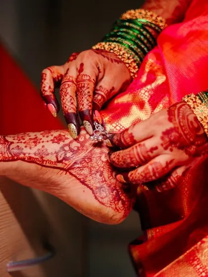 A close-up of the bride's feet, adorned with henna and a toe ring, capturing a traditional and beautiful detail.
