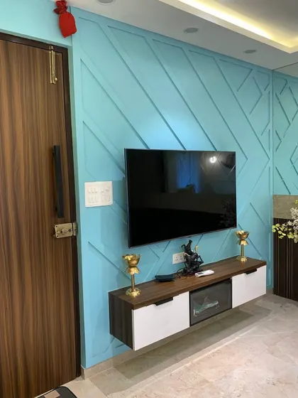 A bold and beautiful TV wall. The entire wall is painted in a striking shade of blue and features a geometric paneling design, making the floating TV console pop.