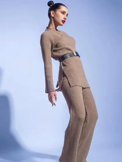A winter fashion editorial featuring a ribbed knit co-ord set. I used a simple blue background and dynamic poses to highlight the texture and silhouette of this chic and comfortable winter outfit.