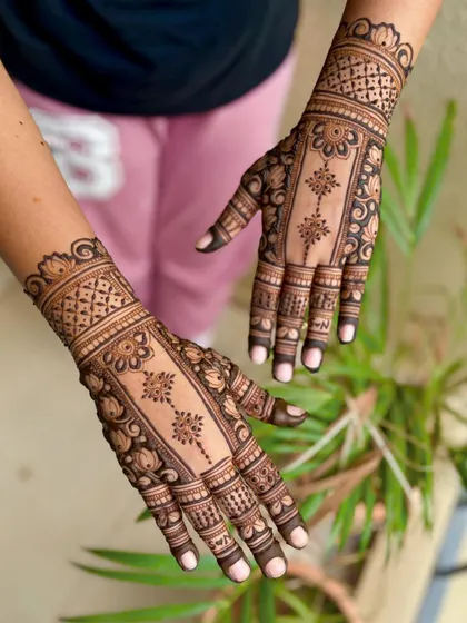 A unique panel-style mehendi for an engagement, featuring a central floral trail framed by intricate borders.