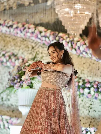 A candid shot of a guest dancing at a reception, with the elegant floral and chandelier decor in the background.