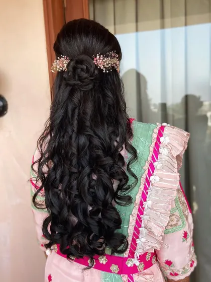 A half-up rose bun with cascading curls, a very romantic and popular choice for engagements and receptions.
