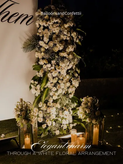 A close-up of the elegant white floral arrangements. I used a mix of white roses and baby's breath, paired with tall glass candle holders, to frame the proposal backdrop with classic charm.