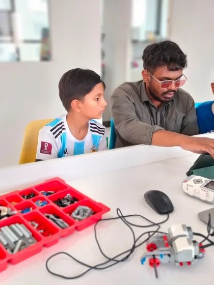 A glimpse from our LEGO Education Summer Camp, where an instructor provides one-on-one guidance to two students working on their robotics project.