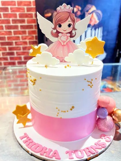 A pink and white angel princess cake, decorated with stars and clouds.