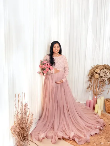 A mother-to-be surrounded by soft light and flowers. This portrait in a beautiful pink gown captures the love and anticipation for the new life to come.