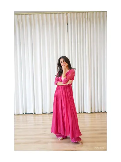 A candid shot from a photoshoot, capturing a moment of quiet joy. This look, in a pink anarkali, represents the grace and elegance of my semi-classical dance style.