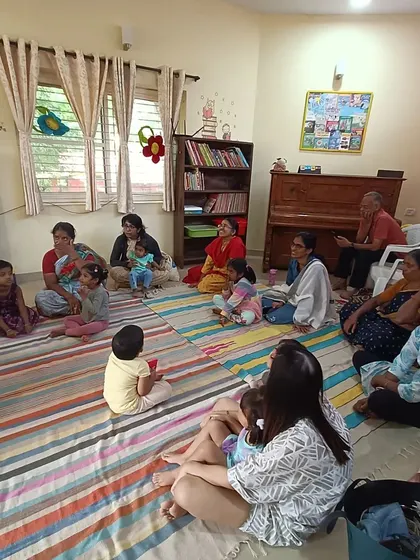A candid shot of the audience, showing parents and children enjoying a quiet moment of listening.
