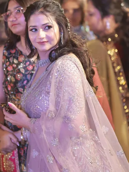 A candid shot of the client at the party. Her makeup looks natural and radiant, even from a distance.
