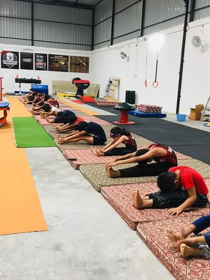 We use pillows and mats to help students safely achieve deeper stretches. This image shows a supervised session focused on improving hamstring and hip flexibility.