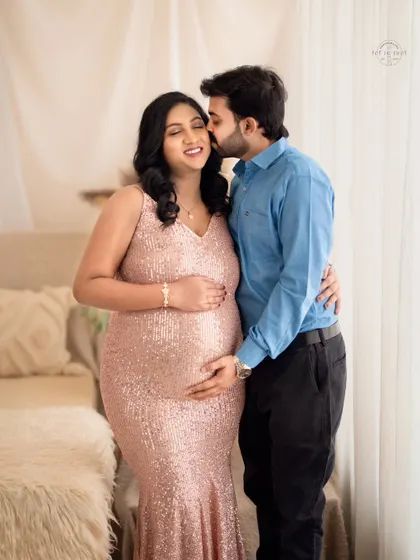 A joyful and candid moment as a husband embraces his wife, both sharing a happy smile.