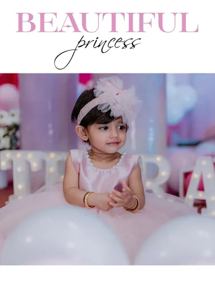 A beautiful portrait of the birthday princess. The soft lighting and the festive balloon background highlight her sweet expression, making for a perfect first birthday memory.