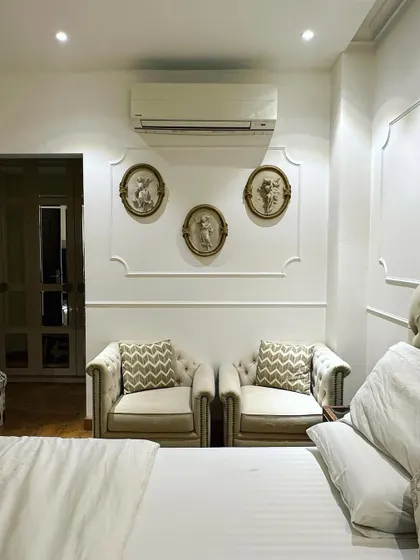 This bedroom corner in a Central Park resort residence features a classic and elegant seating area. I used neo-classical wall moulding to frame the space, where two comfortable armchairs create a perfect spot for reading or quiet conversation.
