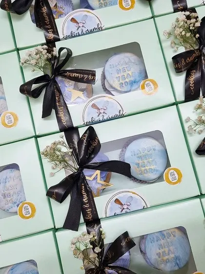 Elegant return favors for a New Year's celebration. Each box contains two customized cupcakes, tied with a branded ribbon and a touch of baby's breath for a sophisticated finish.