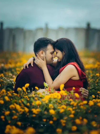 An intimate embrace in a field of yellow flowers. This close-up pre-wedding shot is full of warmth and affection.