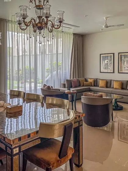 Another view of the open-plan living and dining area, showing how the different furniture styles and art pieces come together. The high ceilings and polished floors create a sense of spaciousness and light.