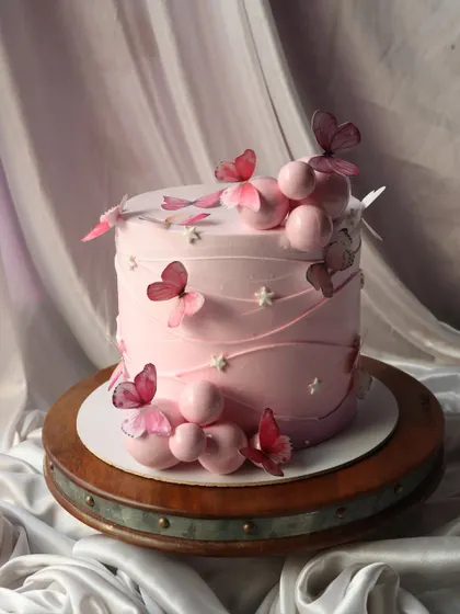 A taller version of the pink butterfly cake, with spheres and butterflies creating a climbing effect.