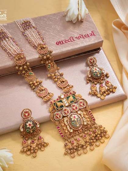 This Maharani Haar is designed to command a room before its wearer even speaks. The grand silhouette features a large, ornate pendant with Bikaneri enamel work, suspended from pearl strands, exuding an aura of sovereignty and exquisite balance.
