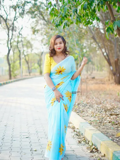 A full-length view of the light blue sunflower saree.