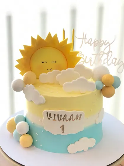 A bright and sunny cake for a first birthday, featuring a smiling sun and fluffy clouds.
