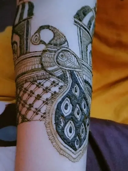 A close-up of a majestic peacock motif, a classic element in Indian bridal henna. The details in the feathers and the shading bring the design to life.