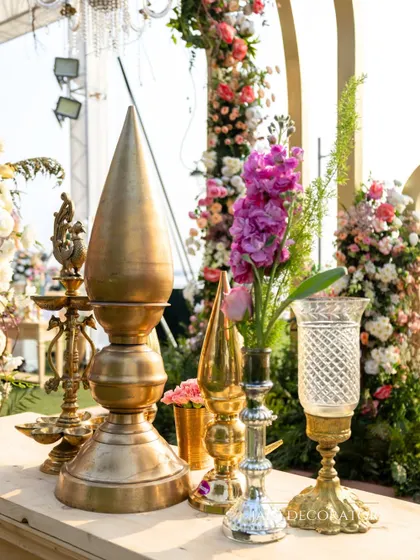 Traditional brass artifacts and fresh flowers create a beautiful and auspicious detail. These small touches help to ground the decor in heritage and add a layer of meaning to the celebration.