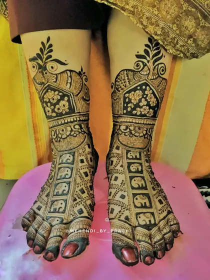 This bridal leg design is filled with mini elephants in a grid pattern, topped with a large floral and peacock cuff. It's a perfect blend of modern and traditional.