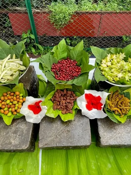 A beautiful spread of nostalgic Indian treats, naturally displayed on banana leaves and stone slabs. It's a rustic and authentic presentation that guests love.