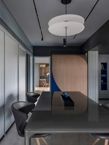 The dining table in 'A Hint of Azul' is positioned to give a direct view of the custom-designed Pooja space at the far end. The arrangement integrates daily rituals into the home's primary social spaces.