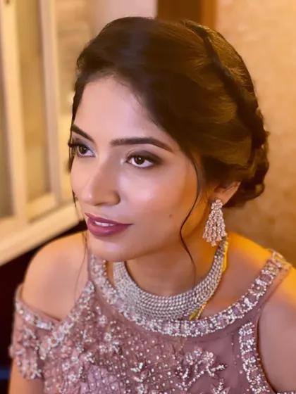 A side profile of Dr. Sunayana, showing how the soft updo and makeup come together for a polished reception look.