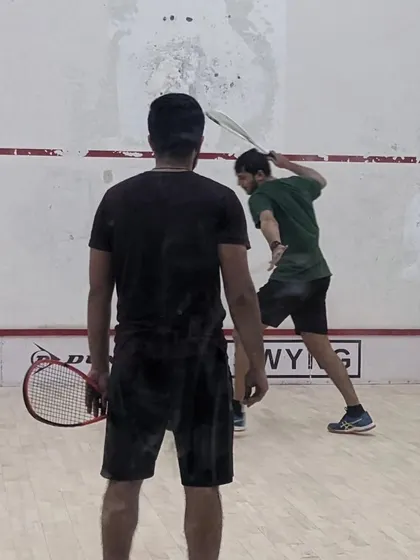 A player executes a powerful backhand shot during a practice rally. Our coaching helps players develop a full range of shots to control the game.