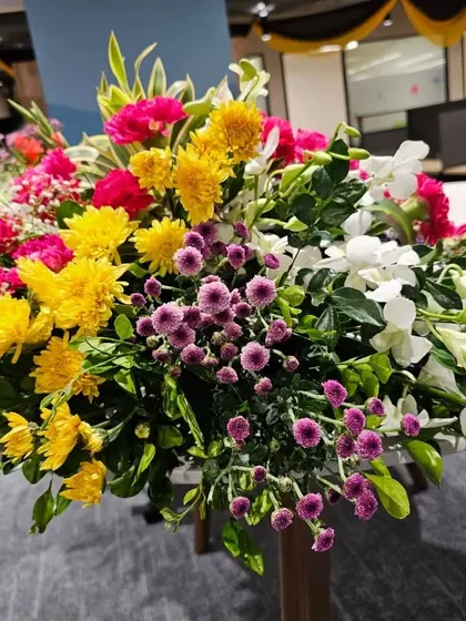 This colorful bouquet, part of the UPS company decor, combines yellow chrysanthemums, pink carnations, and white orchids to create a bright and cheerful atmosphere inside the office.