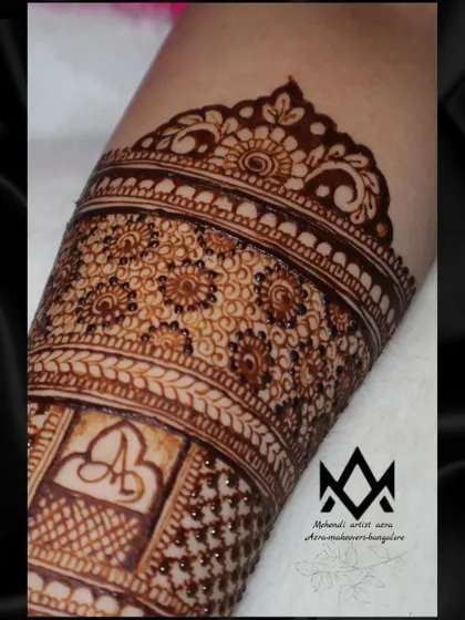 This close up shows the couple's initials 'A' and 'B' subtly woven into the intricate pattern of the bridal mehendi.