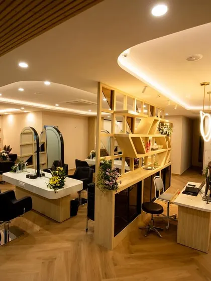 Another perspective of the salon's main area, showing the comfortable tufted sofa in the waiting lounge, the delicate wall art, and the overall warm and inviting atmosphere we aimed to create for a relaxing client journey.