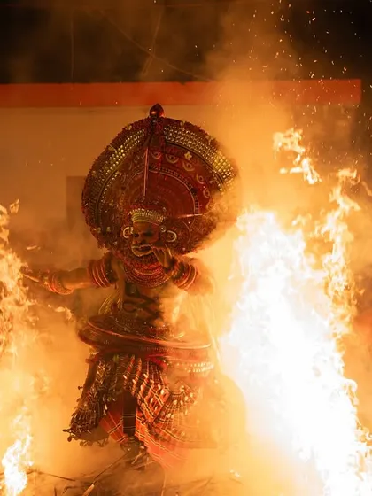A sequence documenting the Kandanar Kelan Theyyam's fearless dance through fire. These images show the performer's complete surrender to the flames, a testament to the ritual's power.