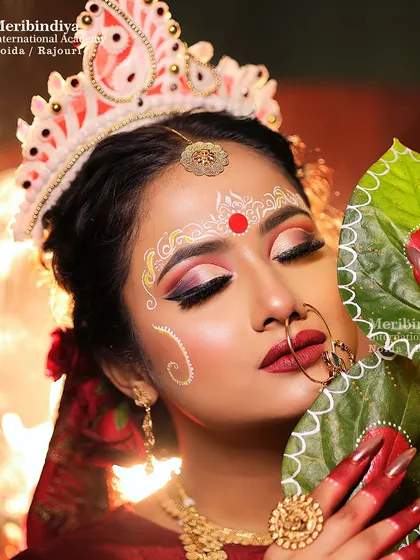 This close-up shows the details of the Bengali bride's hair and makeup, including the placement of the 'mukut' and the artistic forehead decoration.