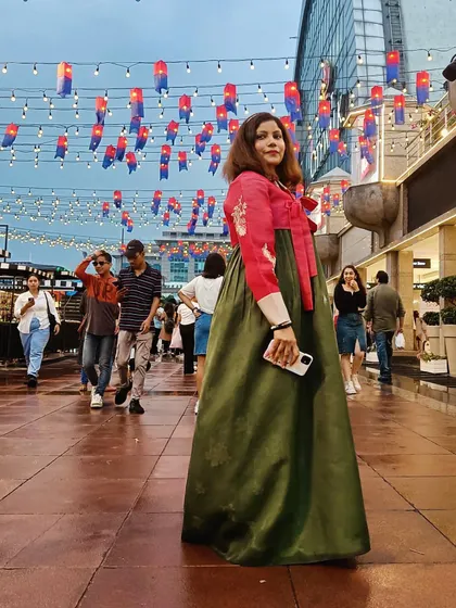 A candid shot of me enjoying the Korean Street Fair in a Hanbok. I capture the live atmosphere of the event, encouraging my followers to participate in future festivities.