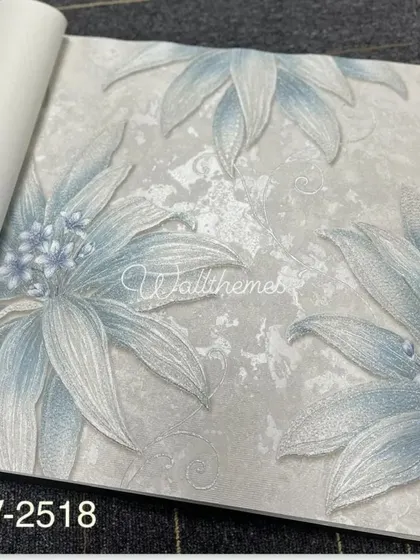 A wallpaper sample with a large, stylized floral pattern in blue on a grey textured background.