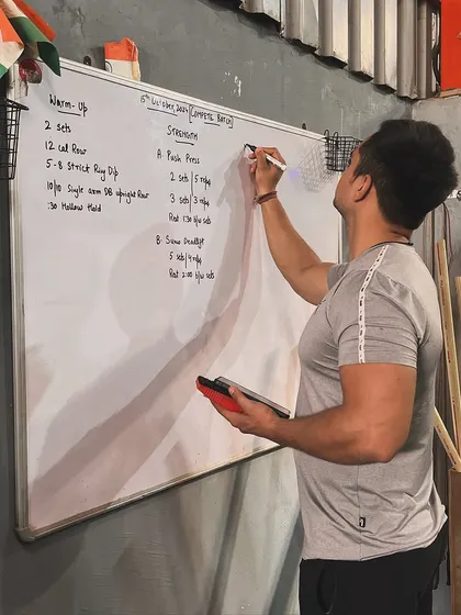 Here I am, planning the day's workout on the whiteboard. Every session is thoughtfully programmed to challenge our members and help them progress towards their goals.