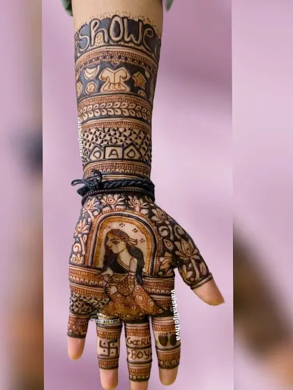 A full-arm baby shower design for a mom-to-be. The mehndi features a portrait of a pregnant woman, with "Baby Shower" and "Maker Boy" written on the arm.