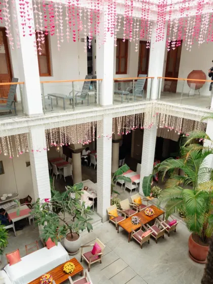 The entire venue becomes a part of the story. Here, hanging floral decorations in the courtyard create a beautiful rhythm, echoing the traditional architecture and filling the space with color and life.