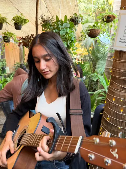 A talented guitarist lost in her music. Our green oasis provides a beautiful and inspiring stage for artists.