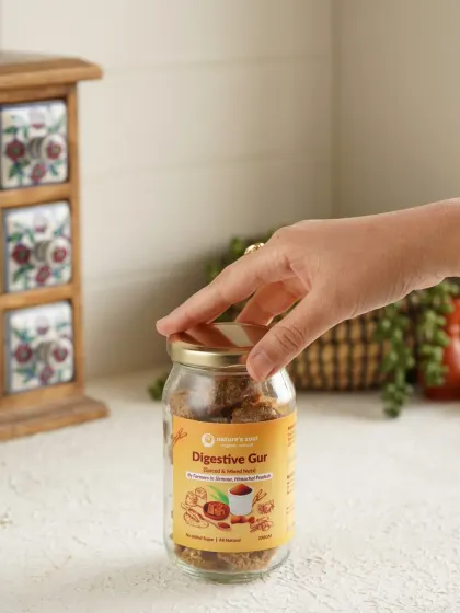 A simple, clean shot with a hand reaching for the jar of Digestive Gud, adding a human element and suggesting ease of use.