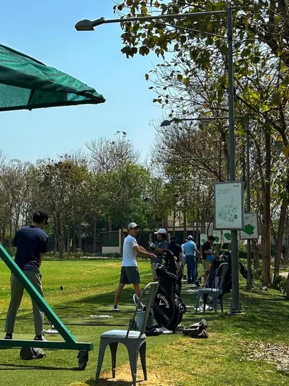 A view from behind the bays shows a full range of golfers enjoying a sunny day.