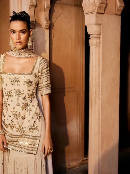 A closer look at the exquisite craftsmanship of the beige sharara set. The square neckline and detailed embroidery on the kurta are incredibly flattering.