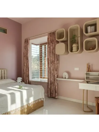 This bedroom in the Shivom project uses a soft pink palette and curved, organic-shaped shelving to create a gentle and serene atmosphere.