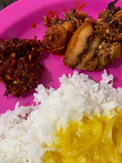 A delicious plate of food featuring pork cooked with dried bamboo shoot, served with dal and my fiery red chilli chutney, which we call Etsu Molu.