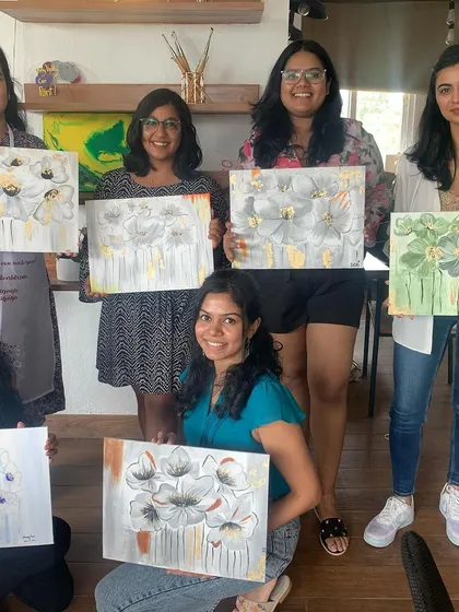 A group of happy participants with their finished floral gold leaf paintings. Everyone's artwork turned out beautifully unique.