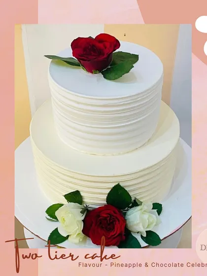 A minimalist two-tier anniversary cake with clean lines and carefully placed red and white roses. This design proves that simplicity can be incredibly elegant.