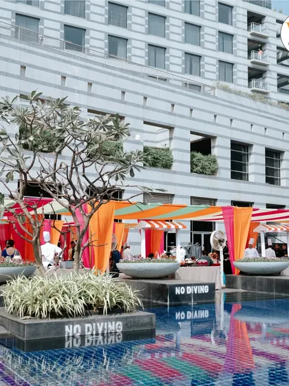 A poolside Mehendi party at the Grand Hyatt Mumbai. The colorful cabanas and decor reflect beautifully on the water, creating a relaxed and festive resort-style atmosphere.